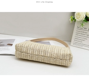 Detail of hand-woven straw shoulder bag with beige texture and smooth brown PU strap
