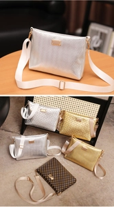 Close-up of metallic cross-body bags featuring chevron and diamond textures with wide straps