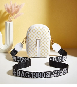 Detail of mini crossbody phone bag with yellow geometric circles and wide woven strap