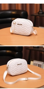 Détail du sac bandoulière matelassé blanc avec surpiqûres vagues et logo doré chic