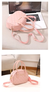 Detailed view of pink quilted PU leather handbag with gold logo and shoulder strap