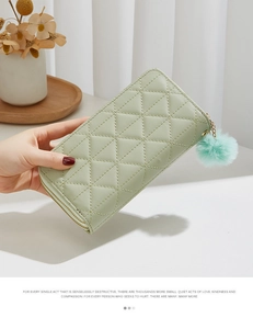 Détail du portefeuille matelassé vert menthe avec fermeture éclair dorée et pompon