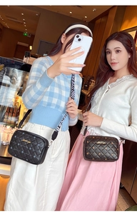 Detail of quilted crossbody bags in black and brown with wide logo shoulder straps