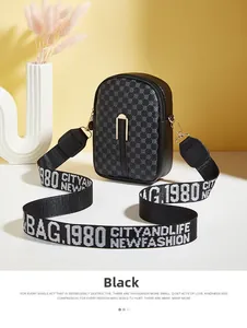 Detail of black crossbody bag with circular patterns and wide branded fabric strap