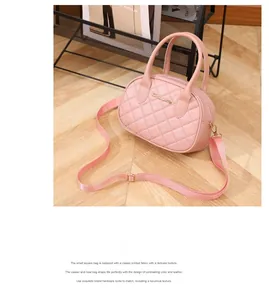 Detailed view of pink quilted leather boston bag with golden logo and wide strap