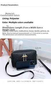 Detail view of black crossbody bag with wave stitching and gold flamingo buckle