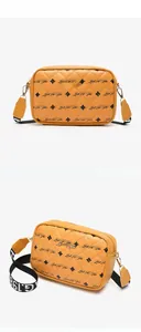 Detail of yellow quilted camera bag with lettering print and branded metal plate