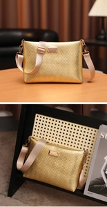 Detail of gold envelope bag with wave pattern texture and wide beige fabric shoulder strap