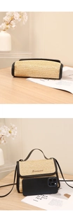 Size comparison of beige straw crossbody bag with a smartphone on wood surface