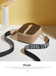 Macro view of khaki mini crossbody bag with vintage monogram and graffiti strap detail