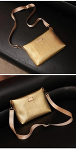Close-up of golden envelope bag with chevron texture and adjustable shoulder strap