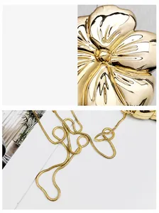 Dettaglio della borsa da sera dorata con fiore metallico 3D e catena a serpente fine