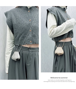 Detailed view of the shell-shaped acrylic evening clutch with a shiny metallic finish