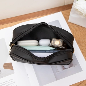 Black wavy embroidered small crossbody bag showing interior capacity for phone and perfume