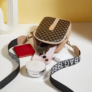 Vintage patterned mini crossbody bag with wide strap showing phone and accessories