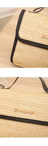 Detailed macro view of beige woven straw handbag with black leather trim and gold logo