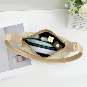 Minimalist beige woven straw shoulder bag with leather trim and gold zipper closure
