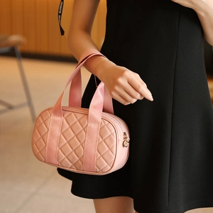 Pink quilted Boston handbag with diamond stitching and adjustable woven handles