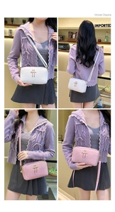 Quilted camera bag with gold flamingo pendant shown in white and pink on a model