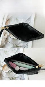 Interior view of black quilted envelope clutch bag showing large capacity for essentials