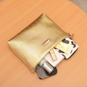 Golden quilted wavy envelope bag with zipper showing internal storage capacity