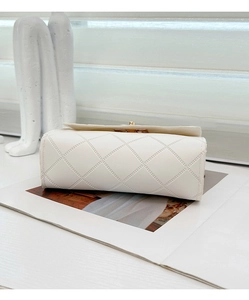 Detailed close-up of white quilted leather bag showing refined bottom and side stitching