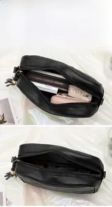 Detailed interior of black quilted camera bag showing space for phone and makeup accessories