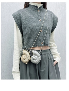 Detailed view of mini shell shaped metal crossbody bags in gold and silver finish