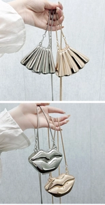 Close-up of metallic shell-shaped and lip-shaped mini bags with sleek snake chains