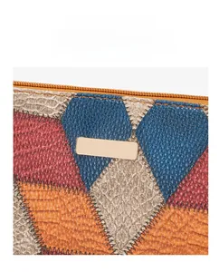 Close-up of geometric leather shoulder bag featuring colorful patchwork and gold zipper