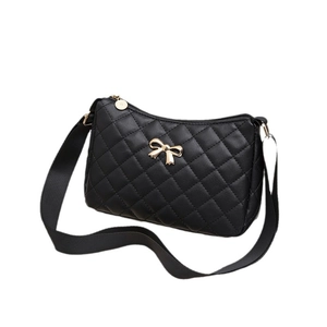 Classic black quilted shoulder bag with golden metal bow detail and zipper on white background