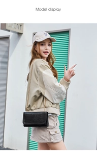 Model display of a black crocodile pattern square bag with a delicate gold chain strap