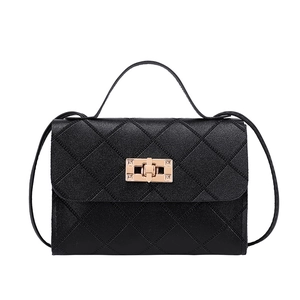 Classic black quilted crossbody bag with gold rectangular clasp and top handle on white background