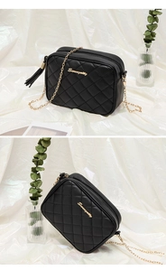 Detail of black quilted leather camera bag with gold chain, tassel, and metallic logo