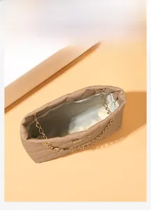 Top view of beige quilted bucket bag showing spacious interior and golden chain strap