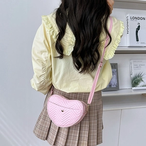 Pink heart-shaped crossbody bag with V-quilted faux leather and gold magnetic buckle
