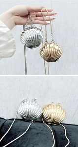 Detail of shell-shaped metallic evening clutch with golden and silver finishes and chain