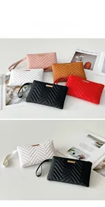 Detail of wave-quilted clutch bags with gold metal trim and leather wristlets