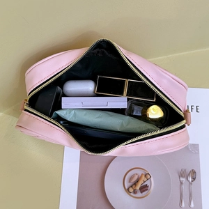Pink heart-pattern embroidered cosmetic bag with gold zipper and spacious interior