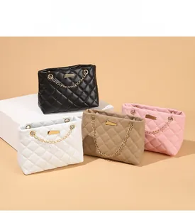 Detail view of quilted PU leather handbags in black white beige and pink with gold chains