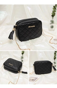 Close-up of black quilted crossbody bag with gold chain strap and tassel detail