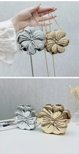 Vista dettagliata delle pochette a fiore metallico con tracolle a catena in oro e argento
