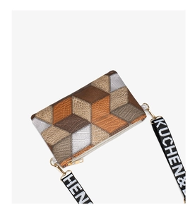 Macro detail of cube patchwork crossbody bag with textured leather and gold zipper