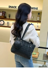 Detailed view of black quilted tote bag with a matching round mini coin purse