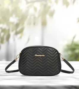 Close-up of black wave-quilted crossbody camera bag with golden S logo and hardware