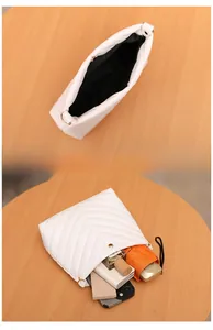 White quilted bucket bag showing interior storage capacity for phone and cosmetics