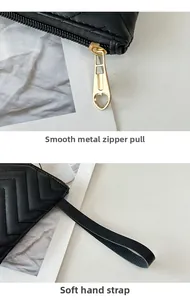 Detail of smooth heart zipper pull and soft wrist strap on black quilted wallet