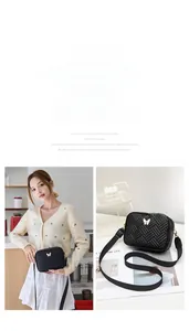 Détail d'un sac bandoulière noir matelassé avec boucle papillon blanche stylée