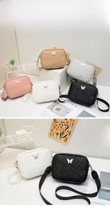 Détail de la texture matelassée en V et du fermoir papillon sur le petit sac bandoulière
