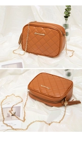 Close-up of brown quilted camera bag with gold chain strap and leather tassel detail
